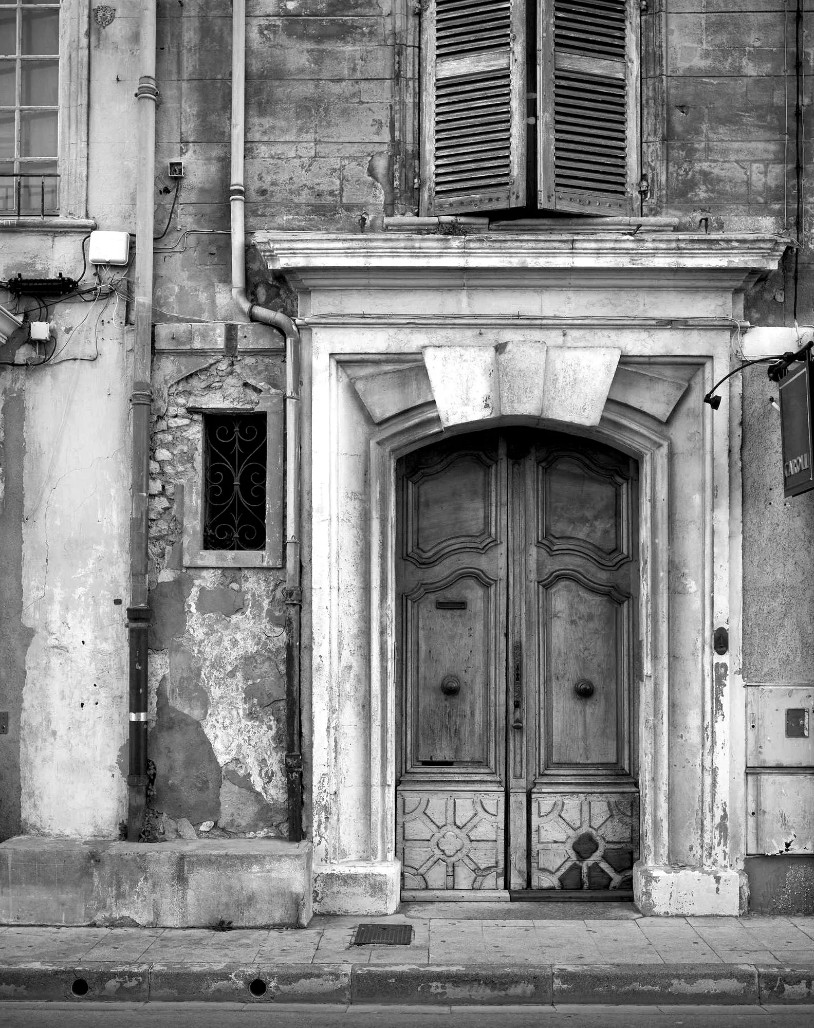 A weathered double door in a stone facade