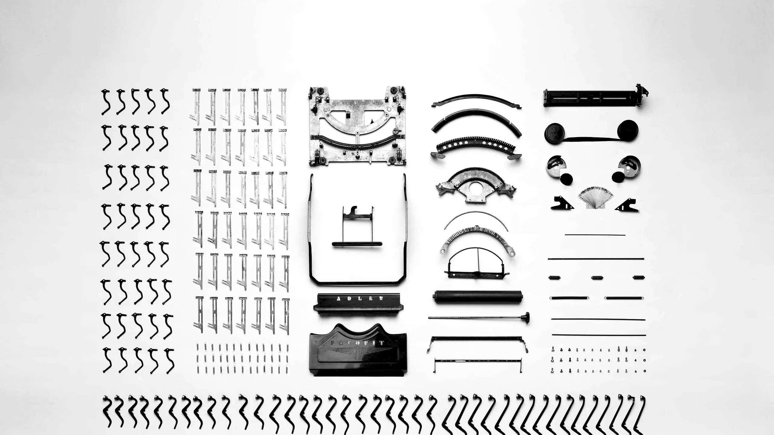 Typewriter parts laid out on white