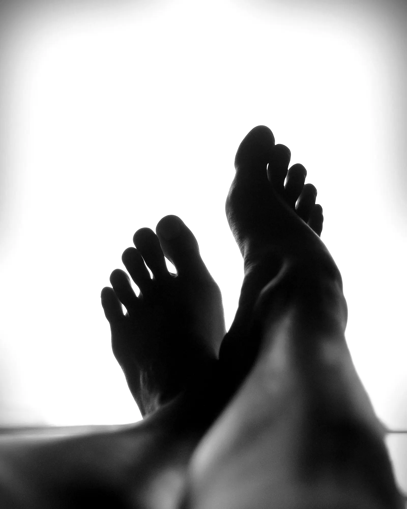 Two bare feet against a bright ground