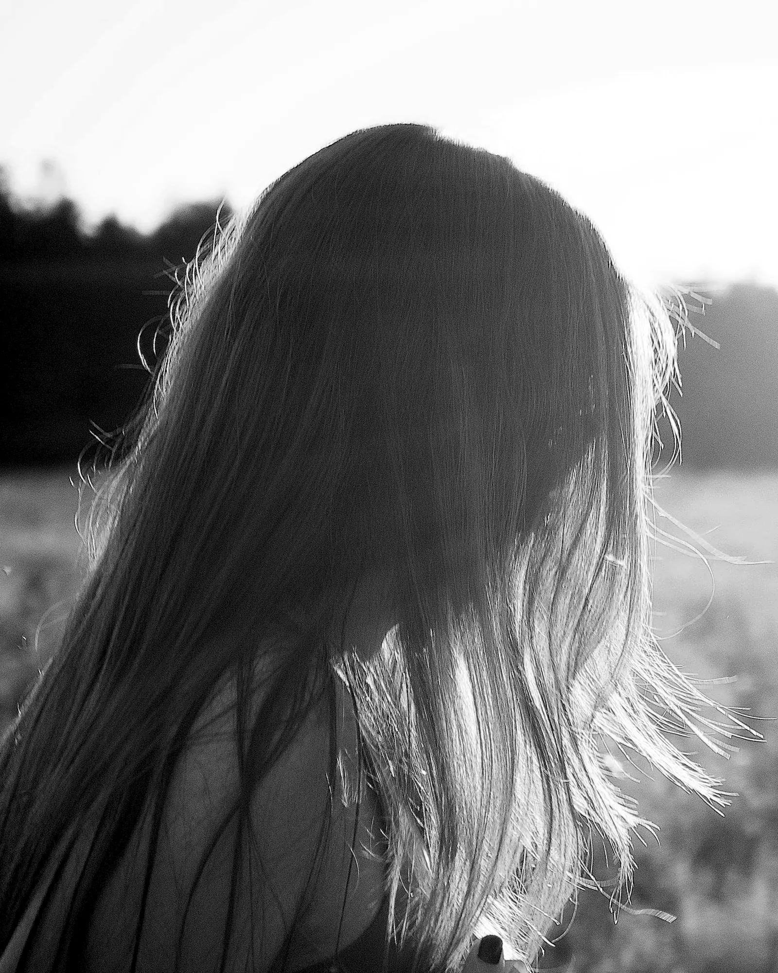 A woman with long hair turned from the camera