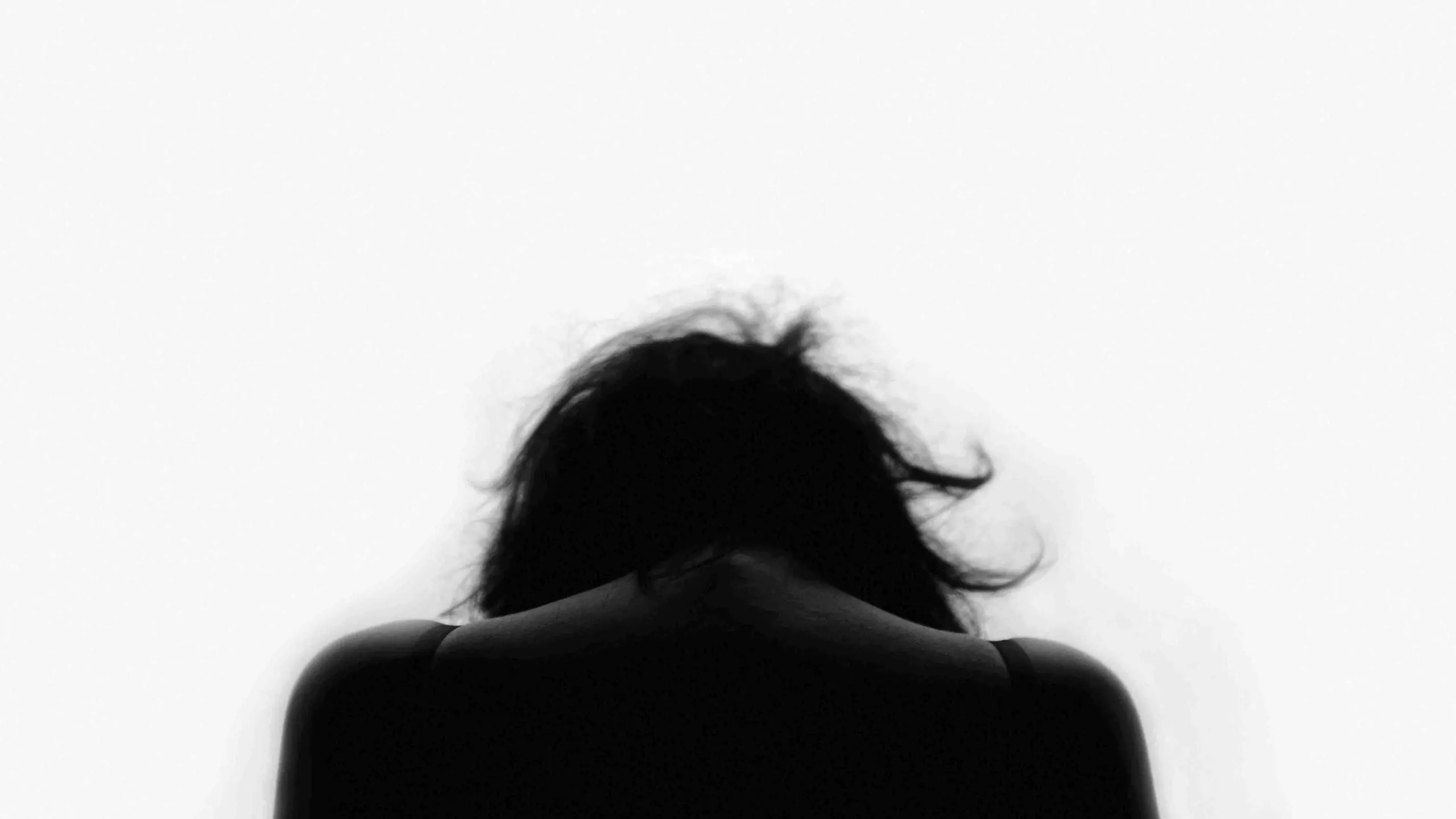 A woman seen from behind, hair lifted by wind