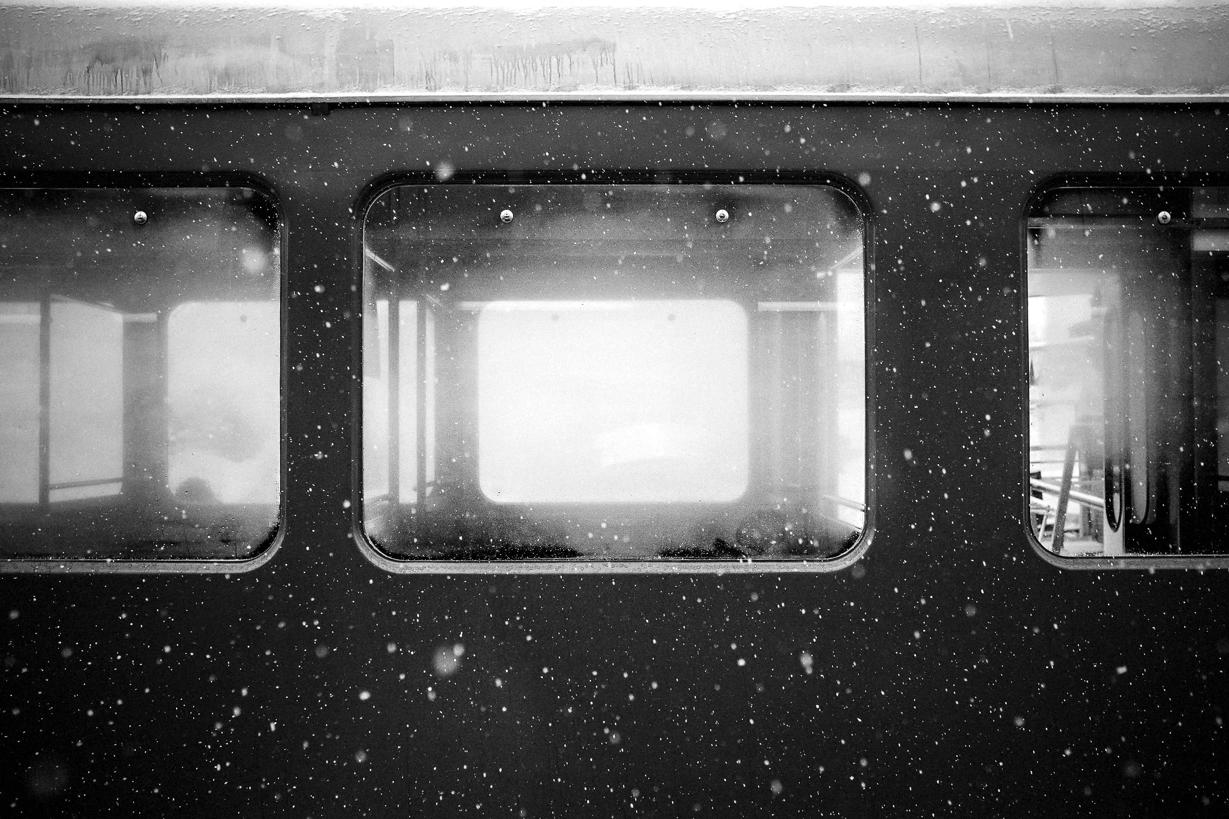 Train windows glowing in falling snow