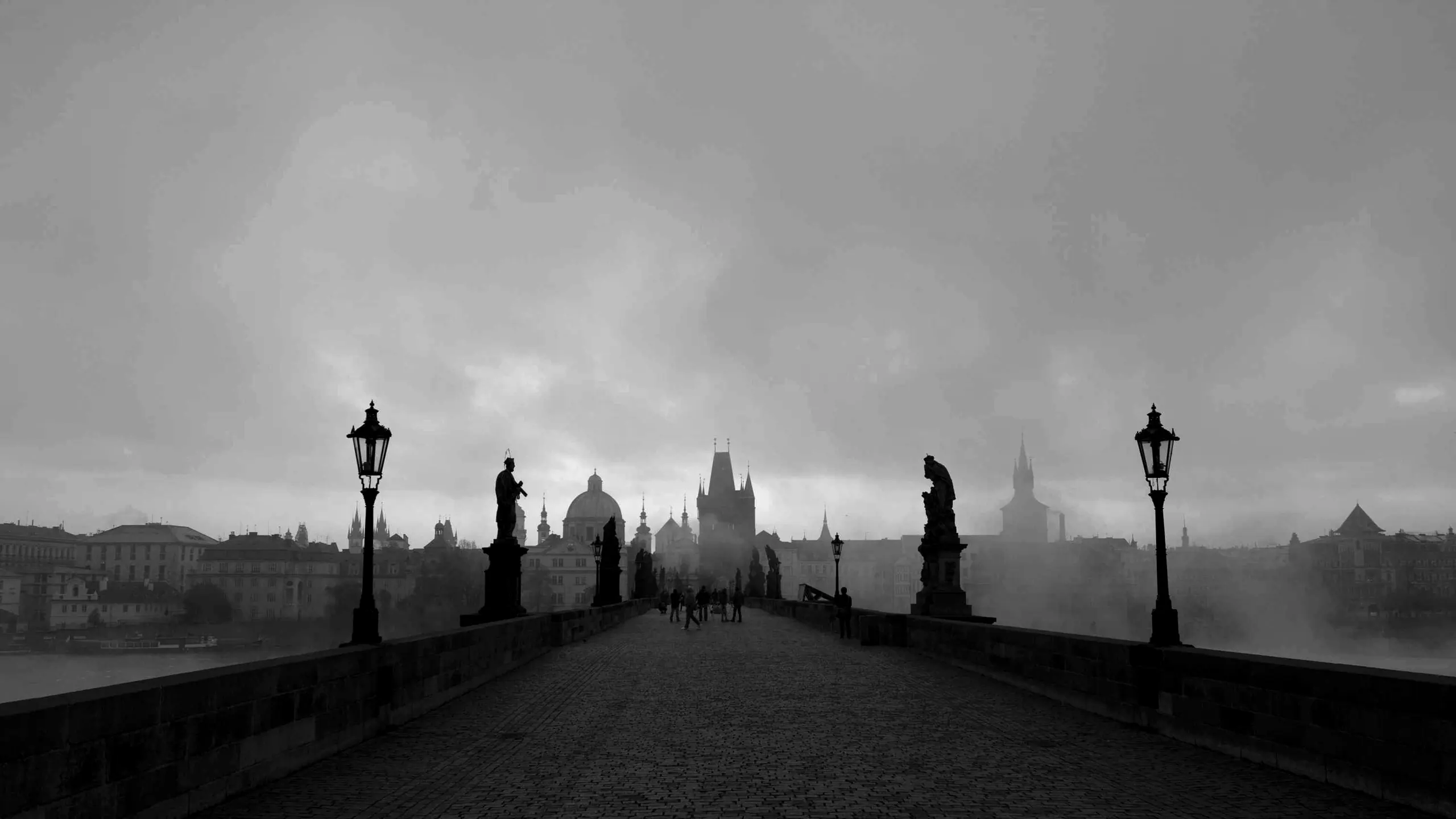 Lamp-lit bridge at dusk in fog